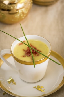 Cup of creamy potato soup and serrano ham chips for Christmas dinner