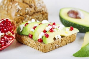 Avocado with Feta, pomegranate on sunflower seeds bread sandwich.