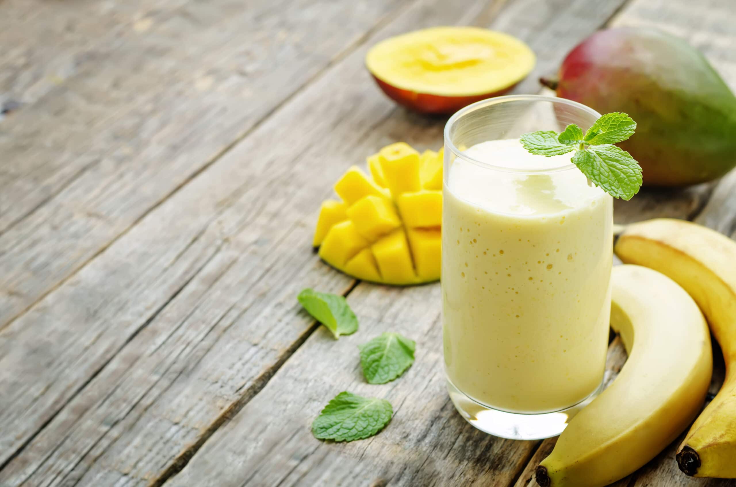 banana mango smoothies on a dark wood background. the toning. selective focus