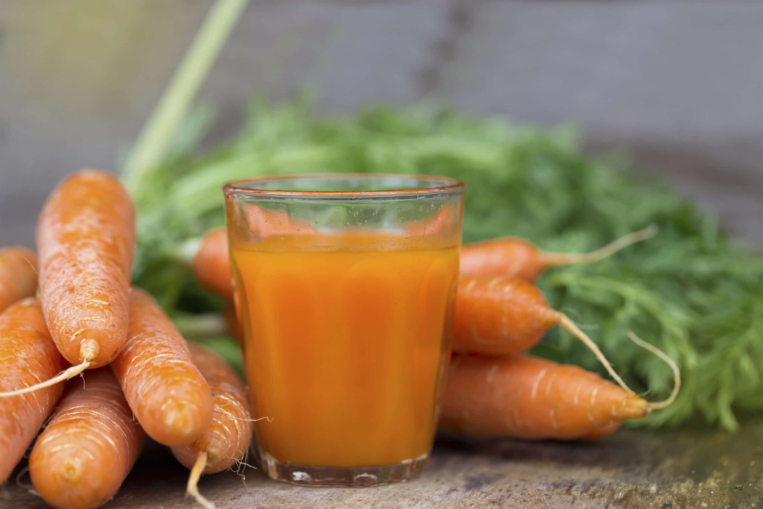 Fresh Carrot juice on a wooden background