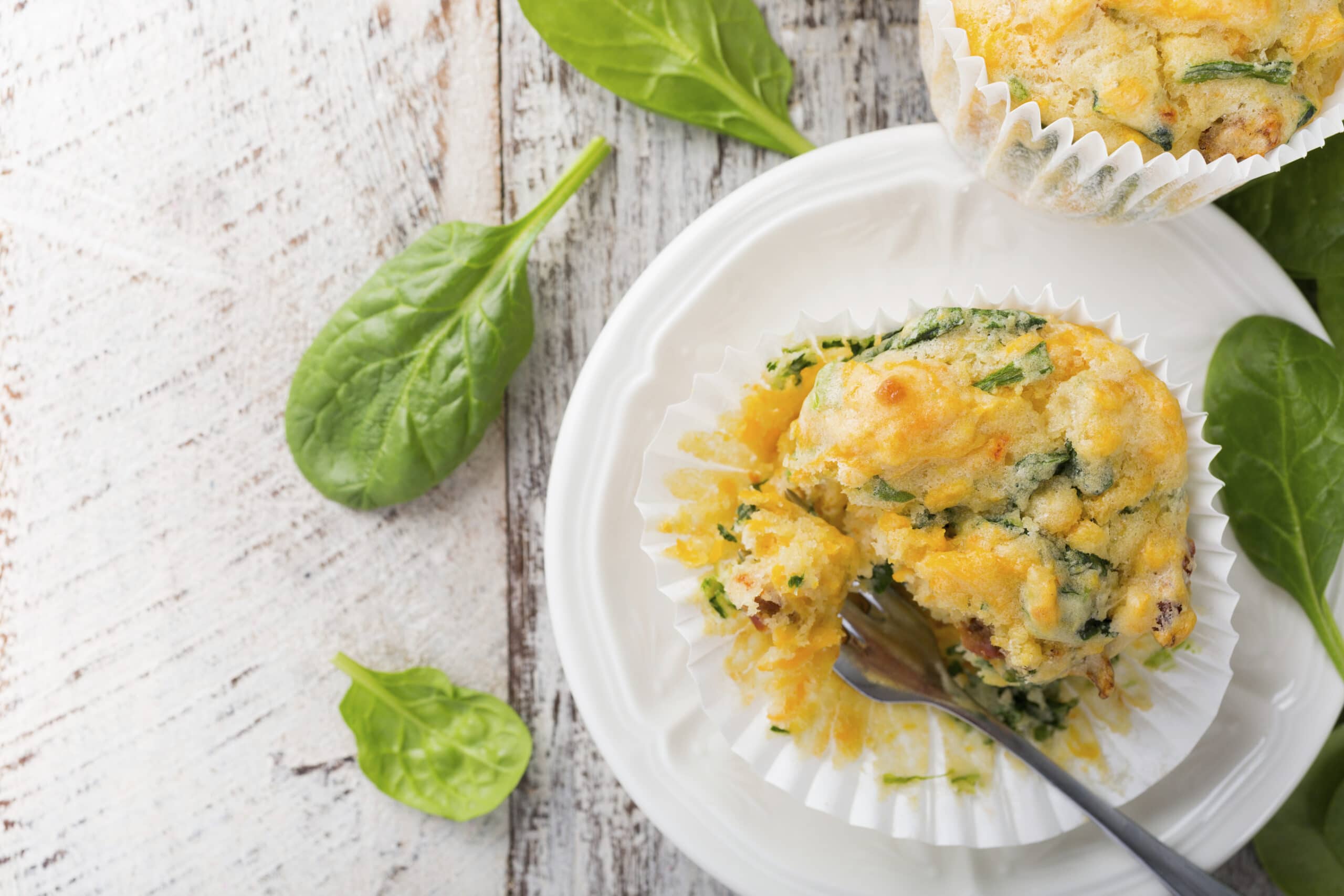 Muffins with spinach, sweet potatoes and cheese on old white wooden background. Healthy food concept with copy space foor text. Top view.