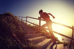 fitness woman runner trail running on seaside mountain stairs, training for cross country running.