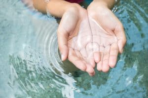 Clear natural water in woman hands.